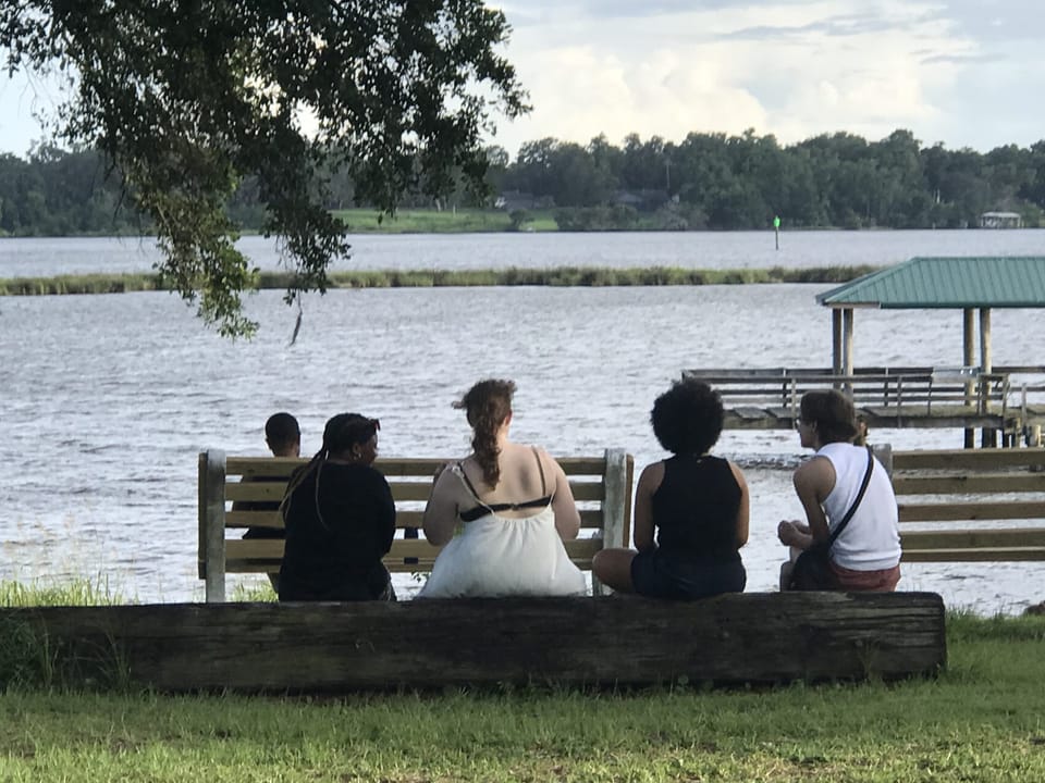 young people sitting at the water in Camp Wilkes, Biloxi, Mississippi